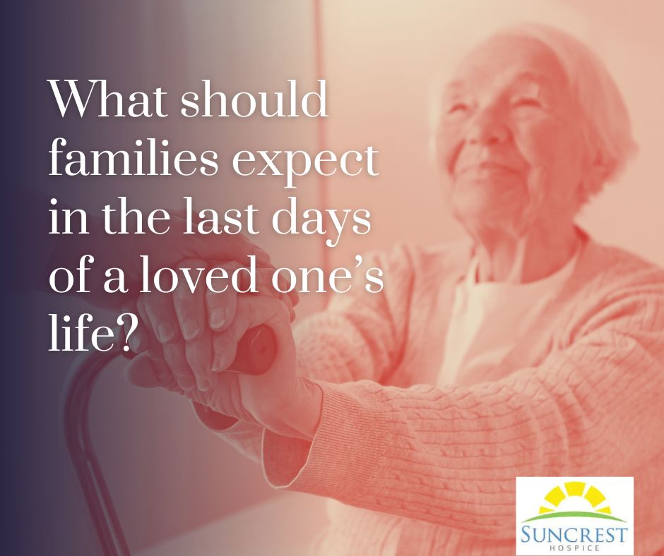 Adult daughter holding her dying father's hand in the last days of his life